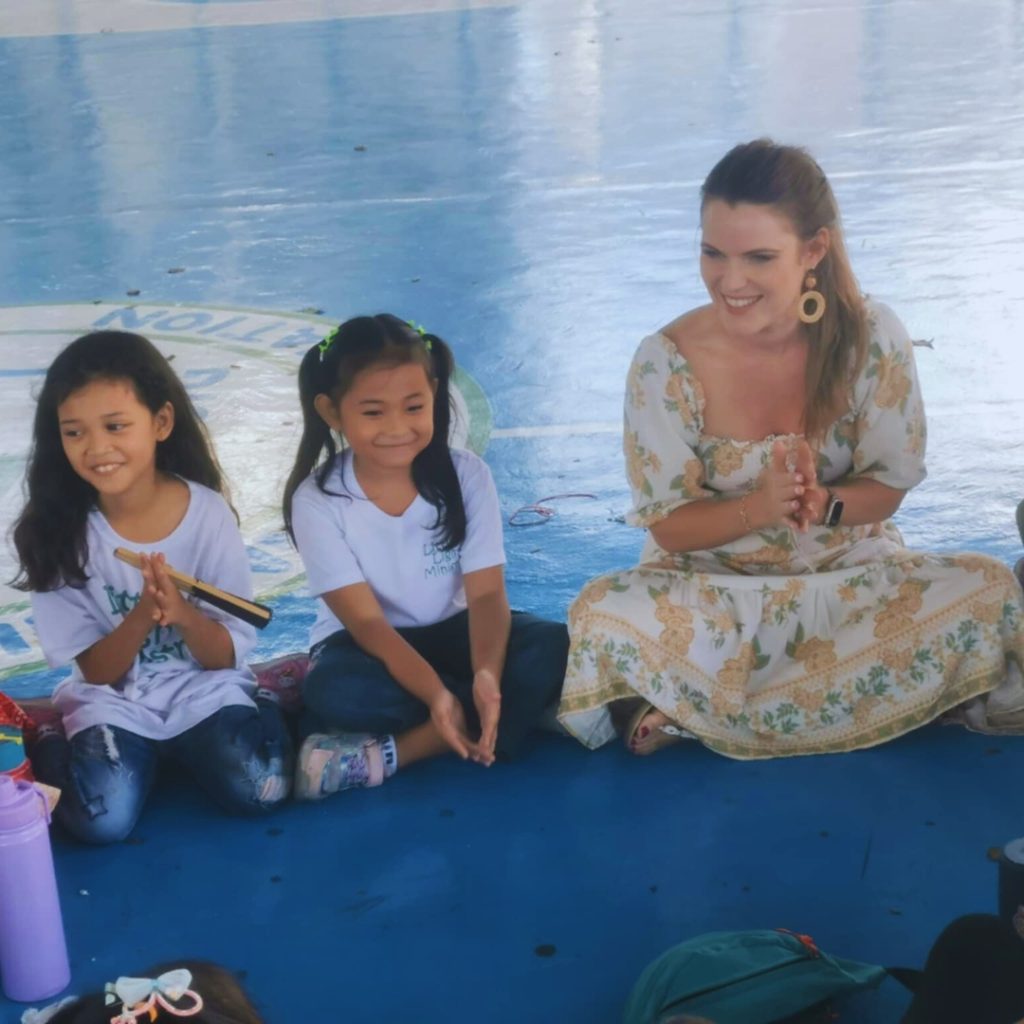 Smiling woman and kids clapping.