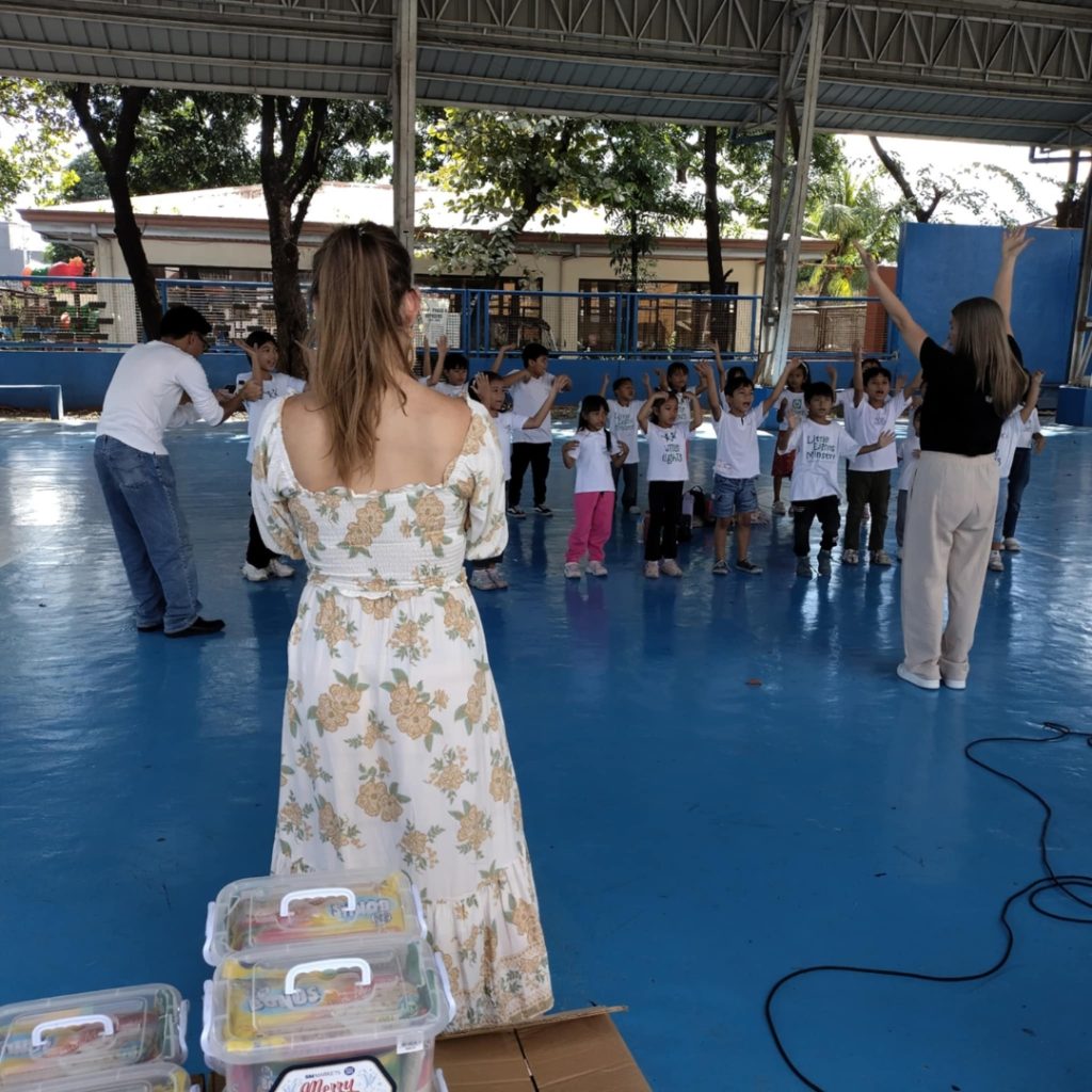 Woman observes kids in activity.