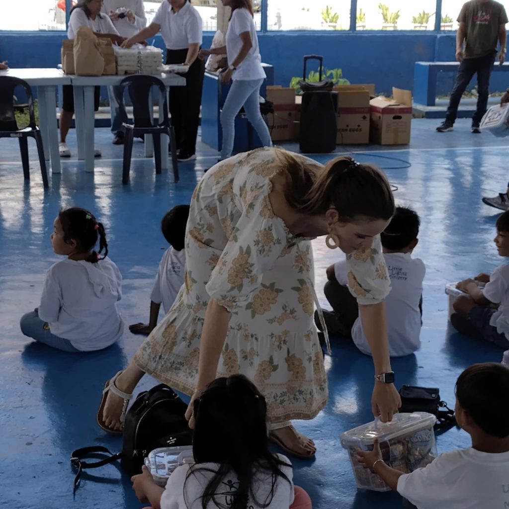 Woman hands supplies to children.